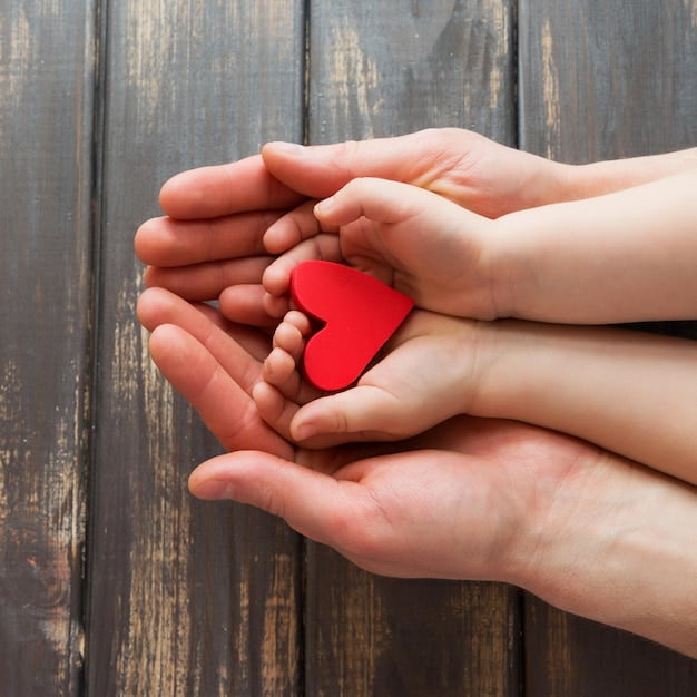 two-pairs-hands-men-children-wooden-background-four-hands-are-holding-red-bright-heart_590597-1308